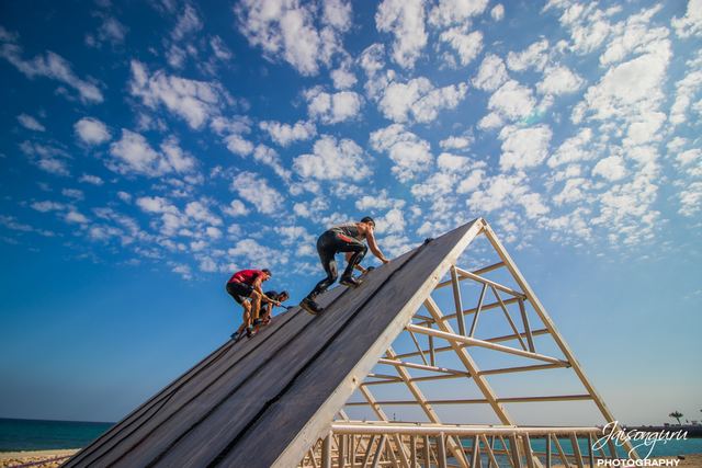 Racer scaling a steep ramp against a cloud-streaked sky
