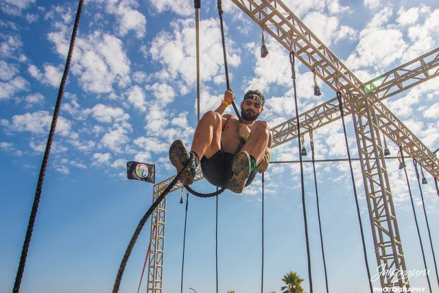 Athlete hauling along a rig of ropes and rings