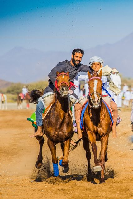 Two jockeys neck and neck at full gallop