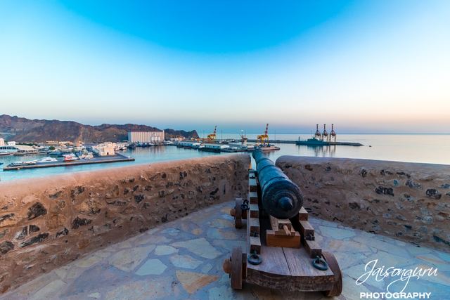Old cannon on a fort rampart pointing out over the harbour