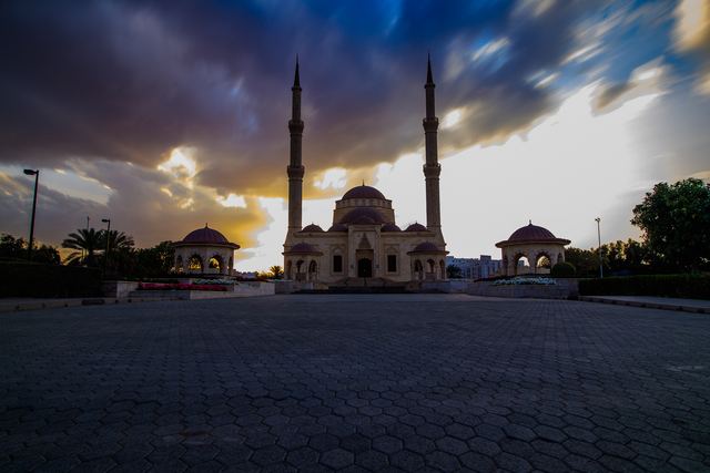 Mosque courtyard under heavy grey cloud at dusk
