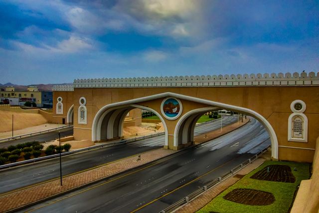 Mutrah Gate arch spanning the road at dusk
