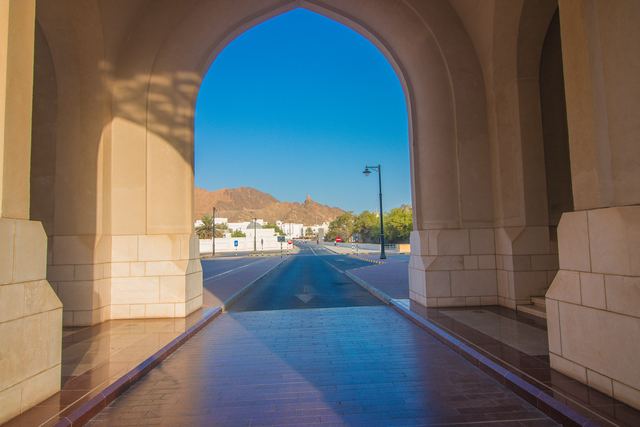 Traditional archway framing an empty road and the mountains beyond