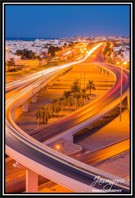 Headlight trails sweeping across a flyover at night
