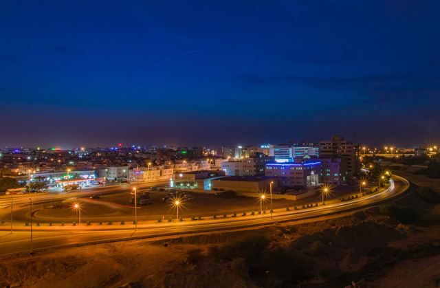 Long exposure of a highway curving through the suburbs at dusk