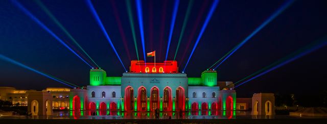 Palace lit in the national colours with laser beams fanning overhead