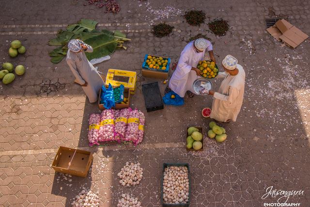 Overhead view of vegetable sellers arranging produce on the ground