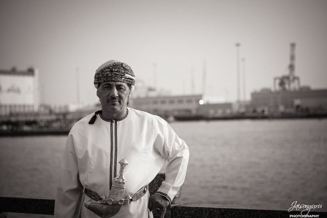 Black and white portrait of an Omani man on the harbour front