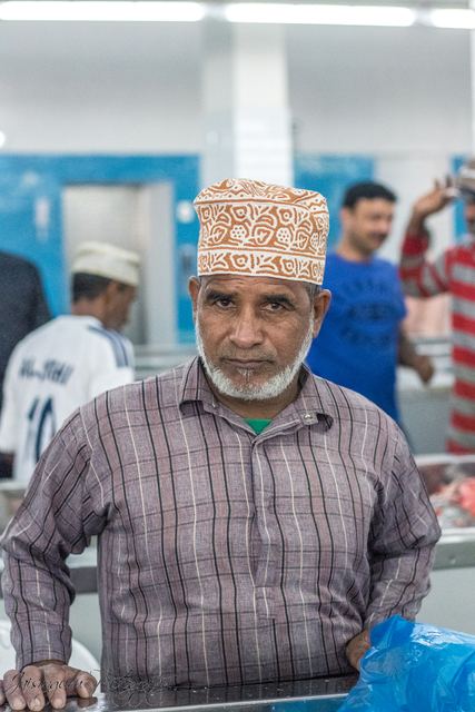 Fishmonger at his counter in the market hall
