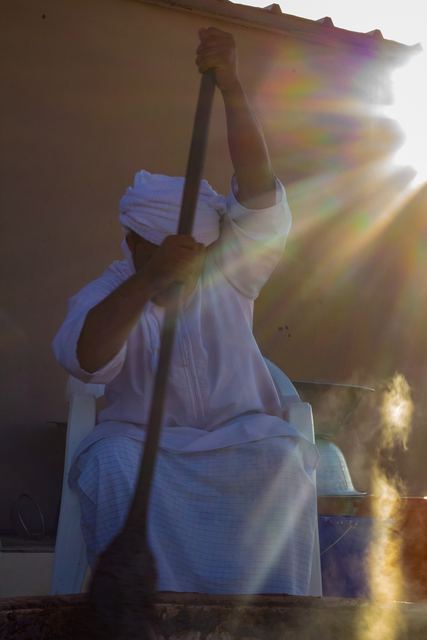 Craftsman working in a shaft of sunlight inside a workshop