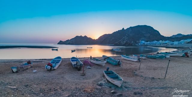 Wooden fishing boats drawn up on the sand at sunrise