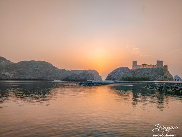 Pale dawn light over still water with a watchtower on the point